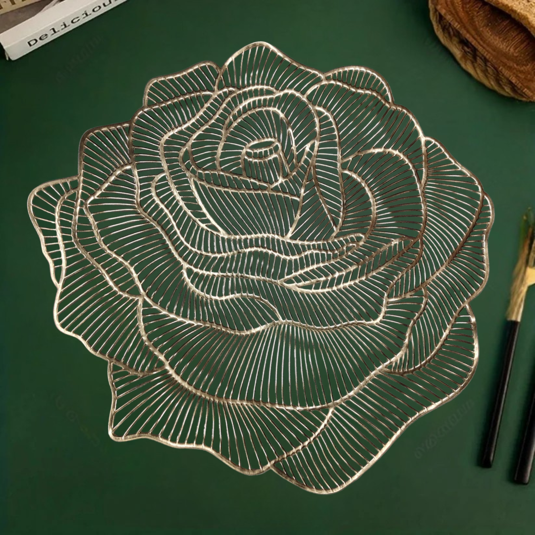 Rose-shaped metallic gold table mat on a green surface, with chopsticks placed beside it.