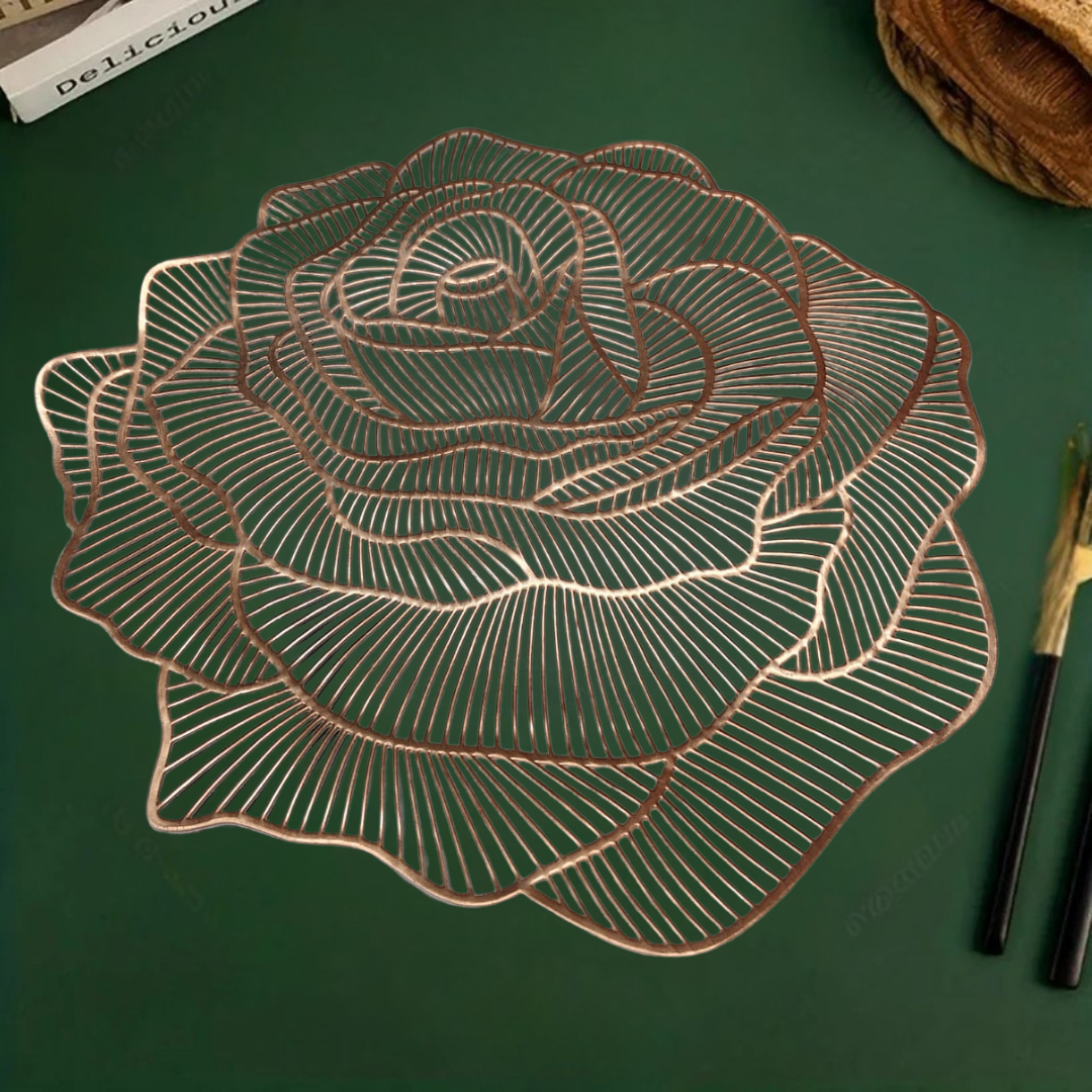 Rose-shaped metallic copper table mat on a green surface, with chopsticks placed beside it.