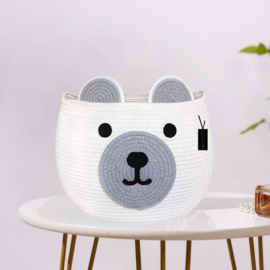 This is a cute white basket designed to look like a bear’s face, with gray ears and snout details. It's perfect for kids' rooms, toy storage, or as a playful decor piece!