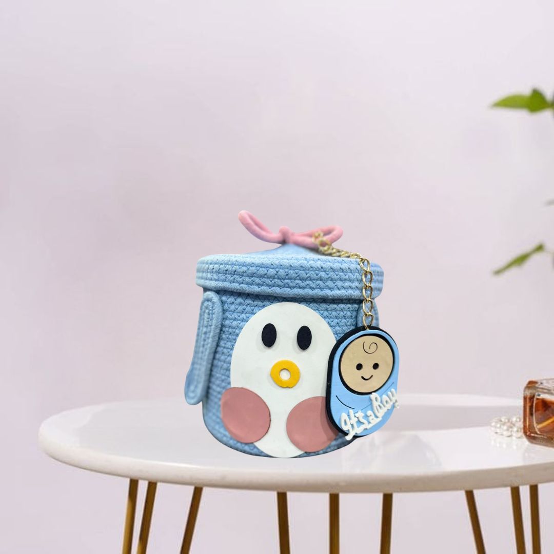 ift basket with “It’s a Boy” label and baby-themed decor.