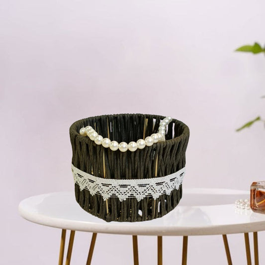 Natural raffia storage basket with decorative beadwork on handle.