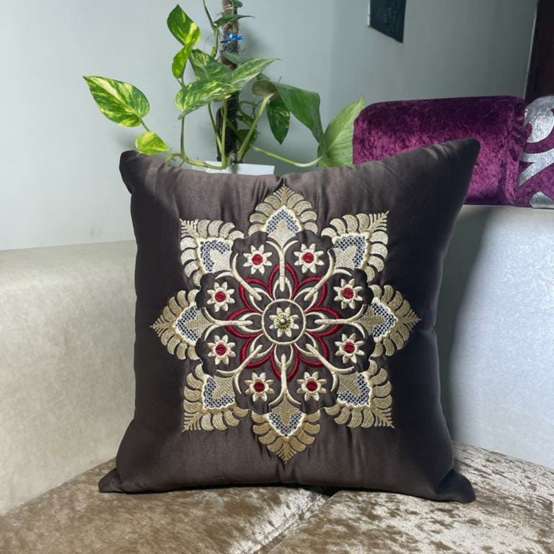 floral embroidered cushion cover in brown color of satin fabric placed on cream colour sofa 