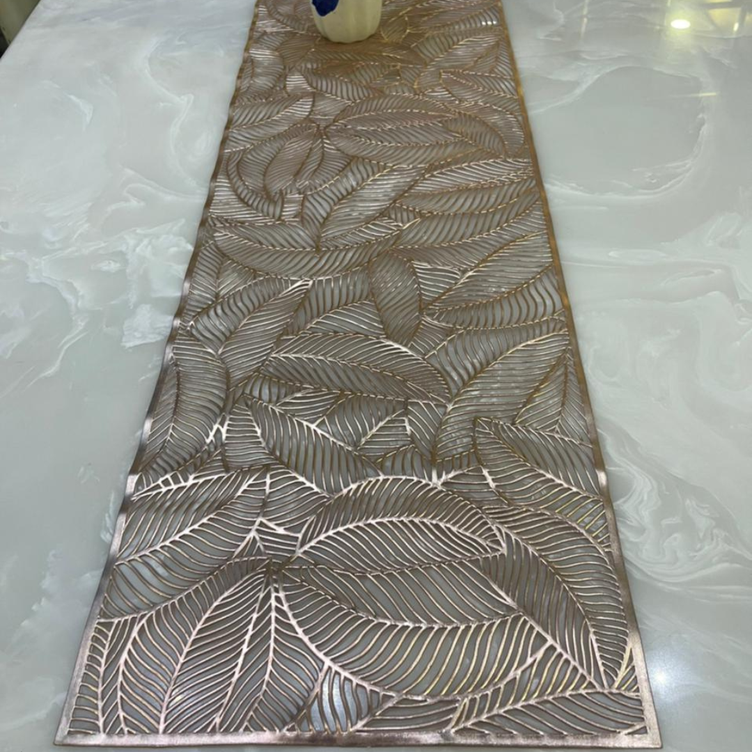 front view of rust table runner metallic look laser cut leaf pattern table runner on white marble dining table