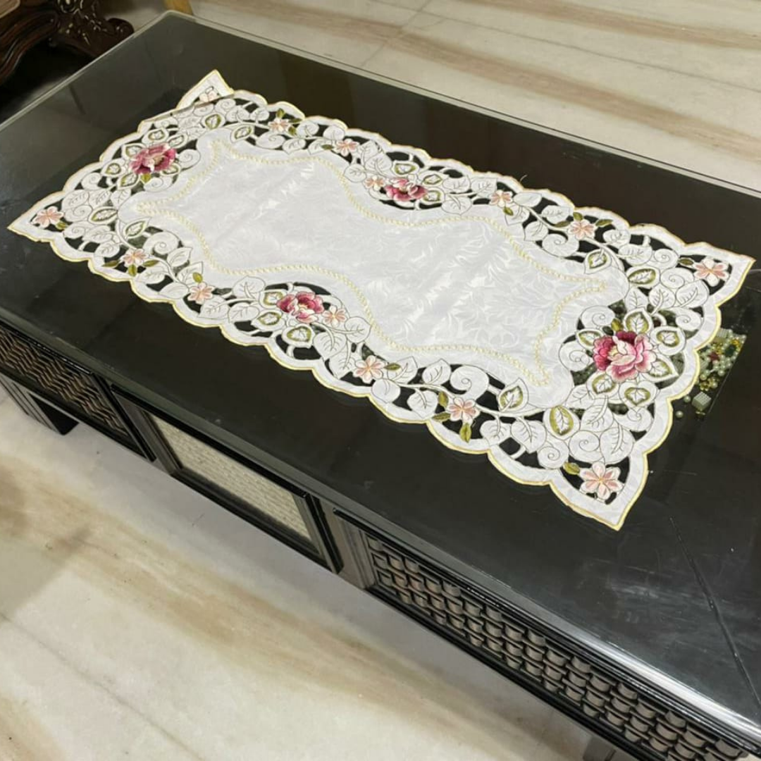 tissue fabric table runner with pink flower and green leaf embroidery placed on glass table