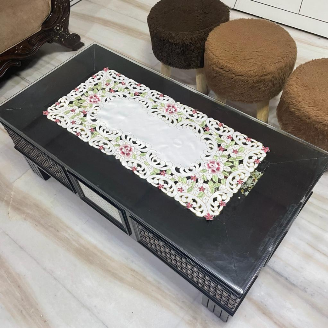 Tissue fabric embroidered with magenta flowers laser cut design placed on table