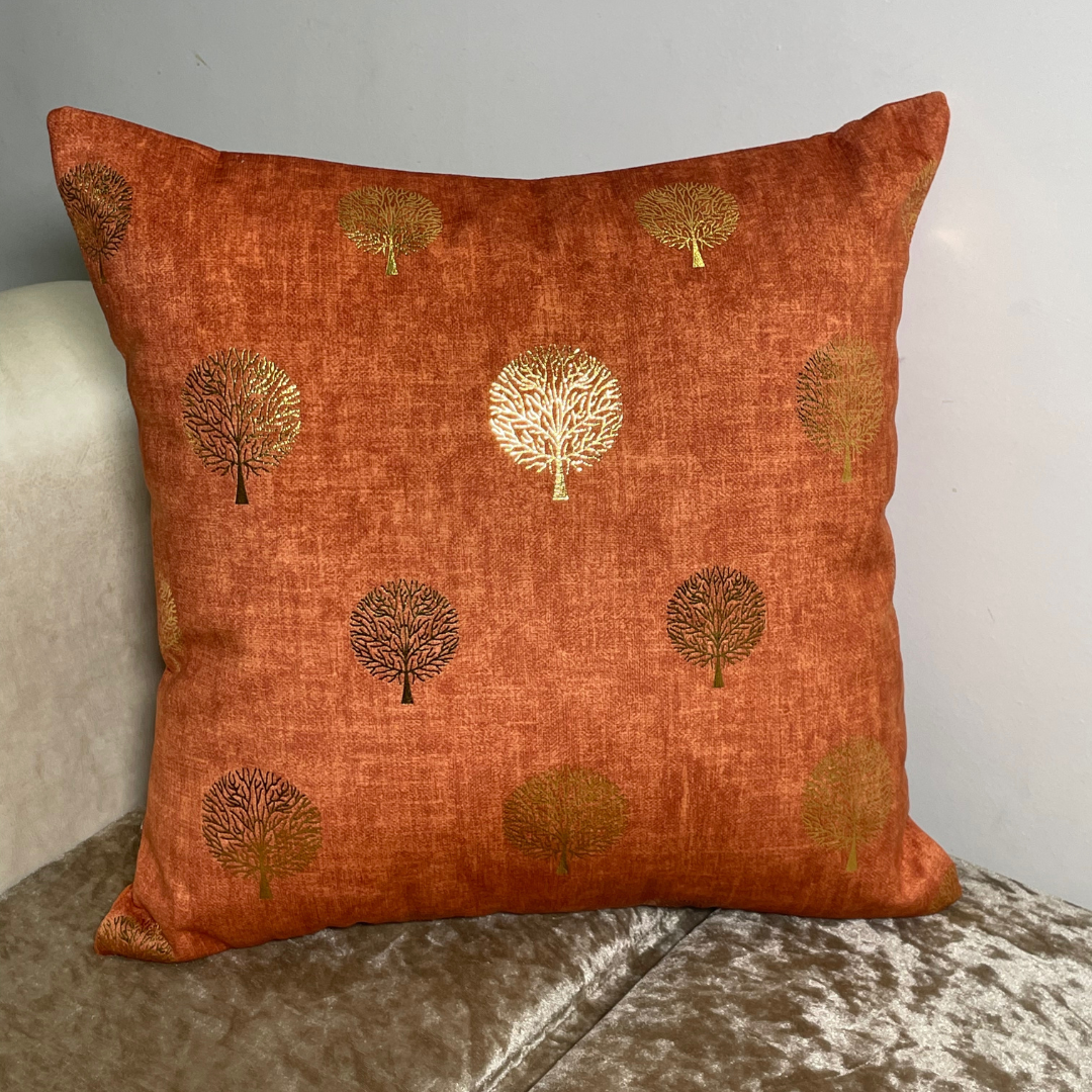 orange cushion cover in velvet fabric tree printed with foil material cushion placed on couch