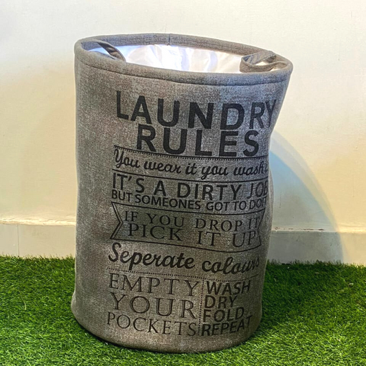 Printed-laundry-basket-in-grey-color-with-closure-placed-on-green-faux-floor