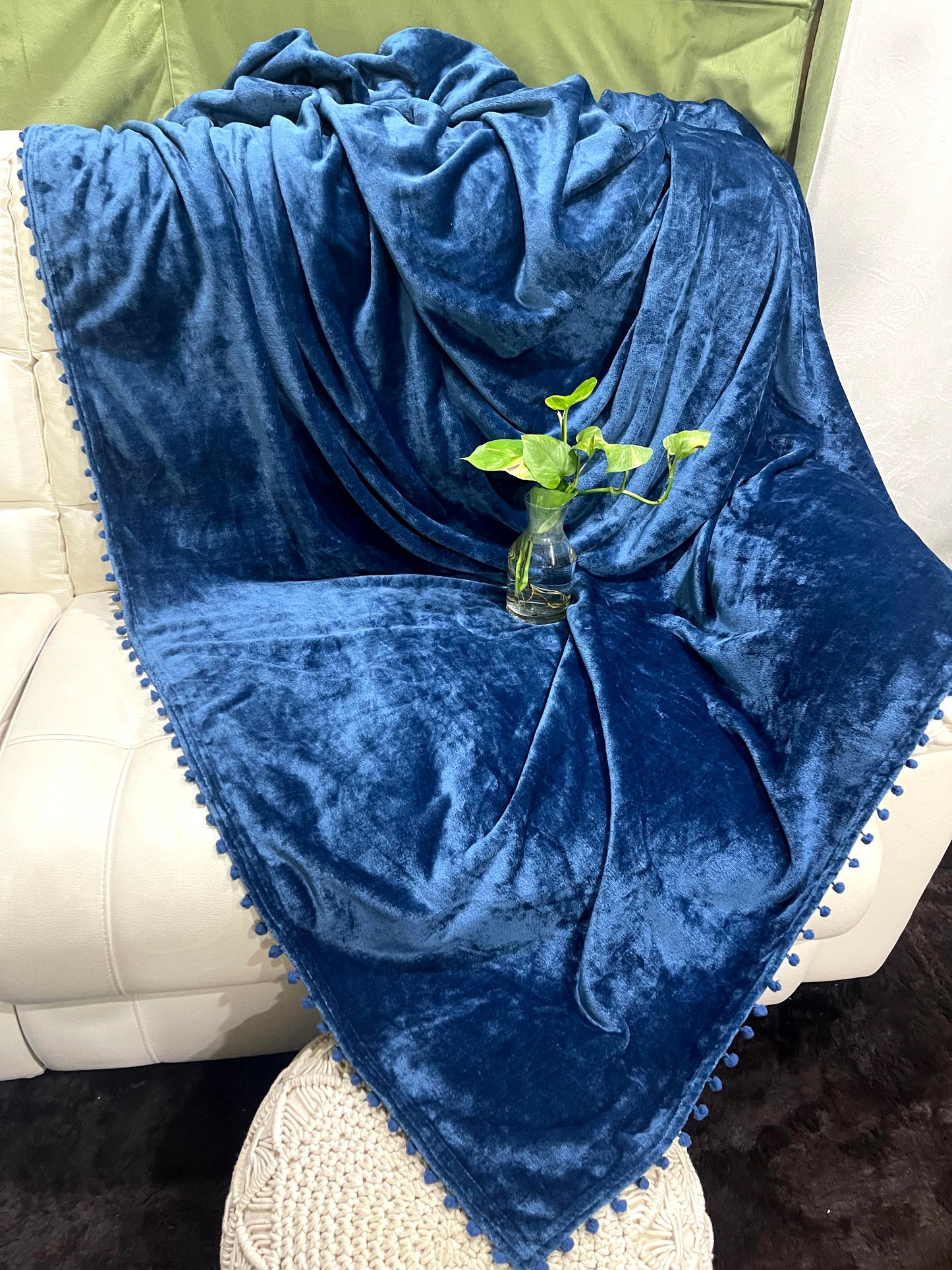 loomsmith-solid-AC-blanket-double-bed-solid-flannel-with-pom-pom-all-four-sides-in-blue-color-placed-on-sofa-ac-use-vibrant-color