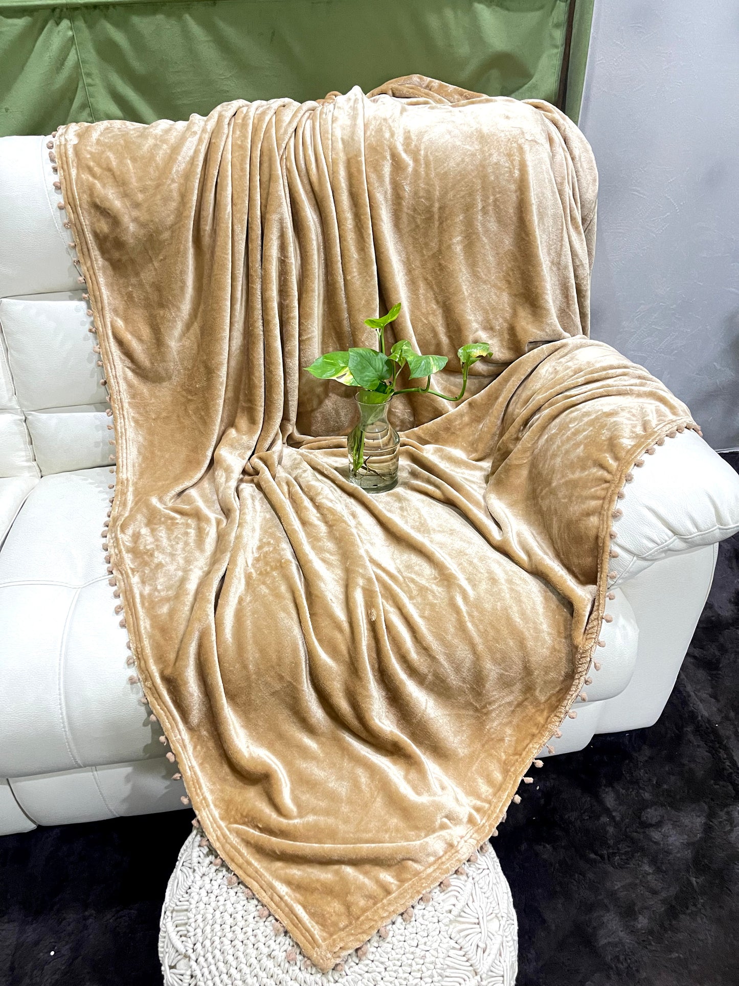 loomsmith-solid-AC-blanket-double-bed-solid-flannel-with-pom-pom-all-four-sides-in-camel-color-placed-on-sofa-ac-use-vibrant-color
