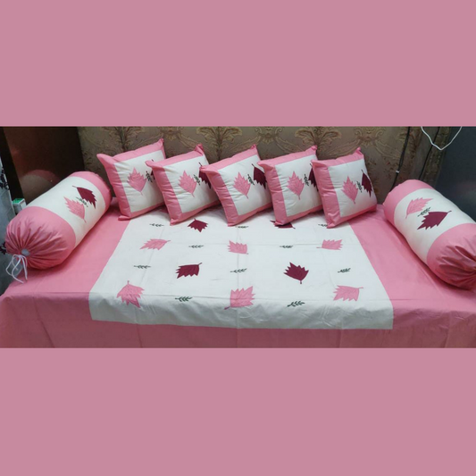 Designer-cotton-diwan-set-flamingo-pink-colour-embroidered-with-five-cushion-cover-and-two-booster-cover-placed-on-bedsheet-in-organized-manner