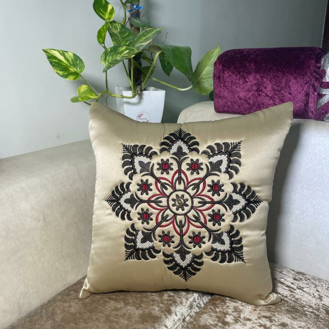 floral embroidered cushion cover in beige color of satin fabric placed on cream colour sofa 