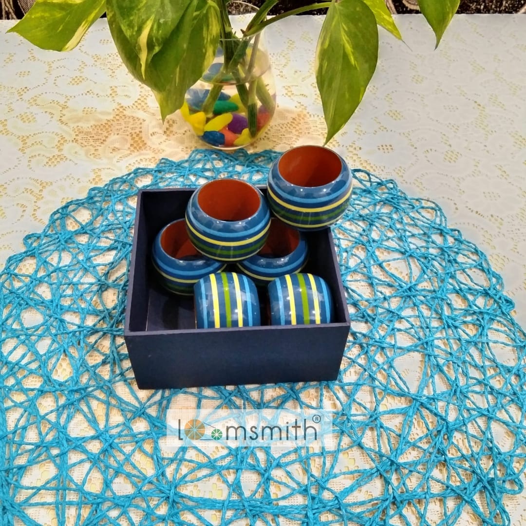 six wooden rings of blue color is placed in a box lying on the table 