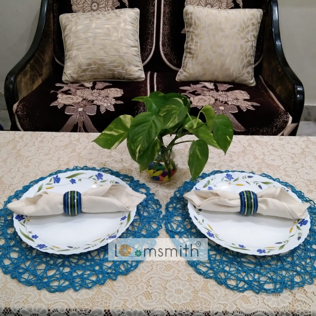 Two wooden rings in blue color placed on the dishes with napkins holding on the table