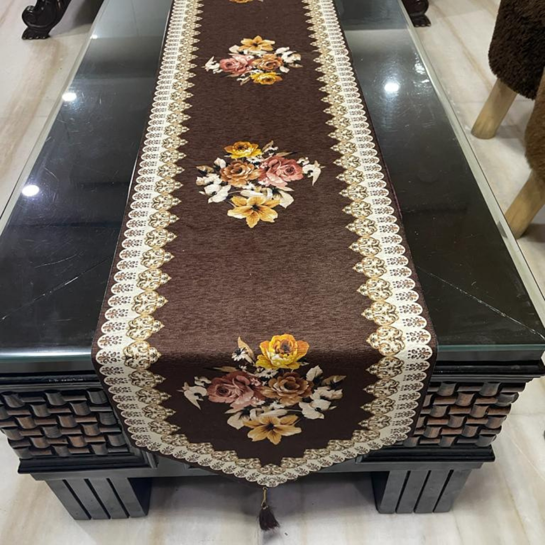 floral printed dining table runner in brown color design with a tassel on both ends borders printed placed on glass wooden table front view