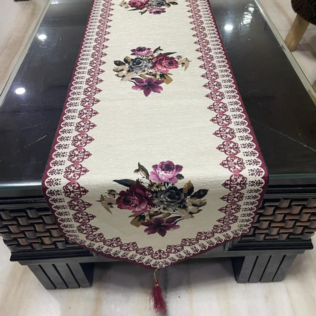 floral printed dining table runner in purple color design with a tassel on both ends borders printed placed on glass wooden table front view