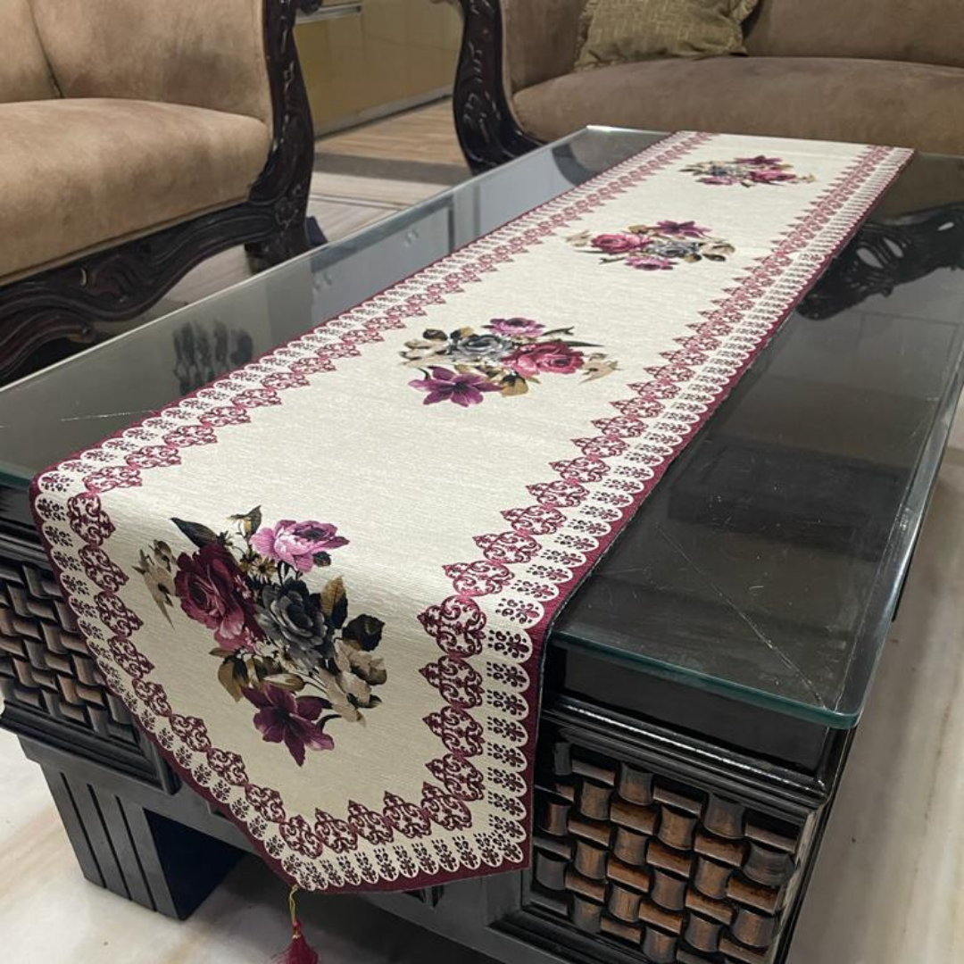 floral printed dining table runner in purple color design with a tassel on both ends borders printed placed on glass wooden table side view