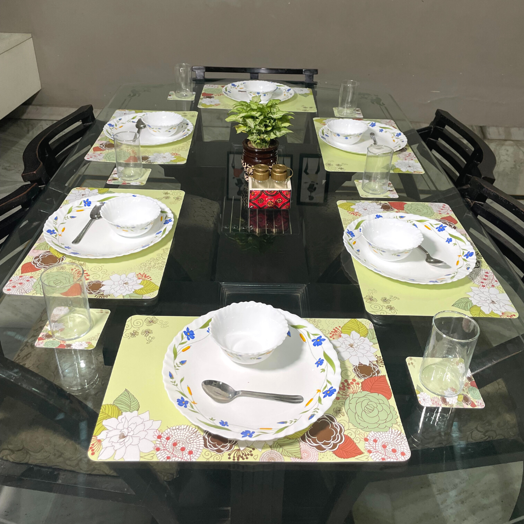 floral printed design in green color dining mats set of 6 with tea coasters placed on glass dining table 