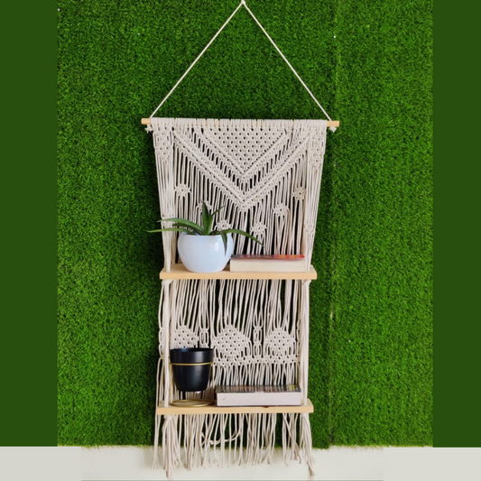 Macrame wooden hanging shelf on wall with faux grass wallpaper two wooden shelves occupied with book and plant holder