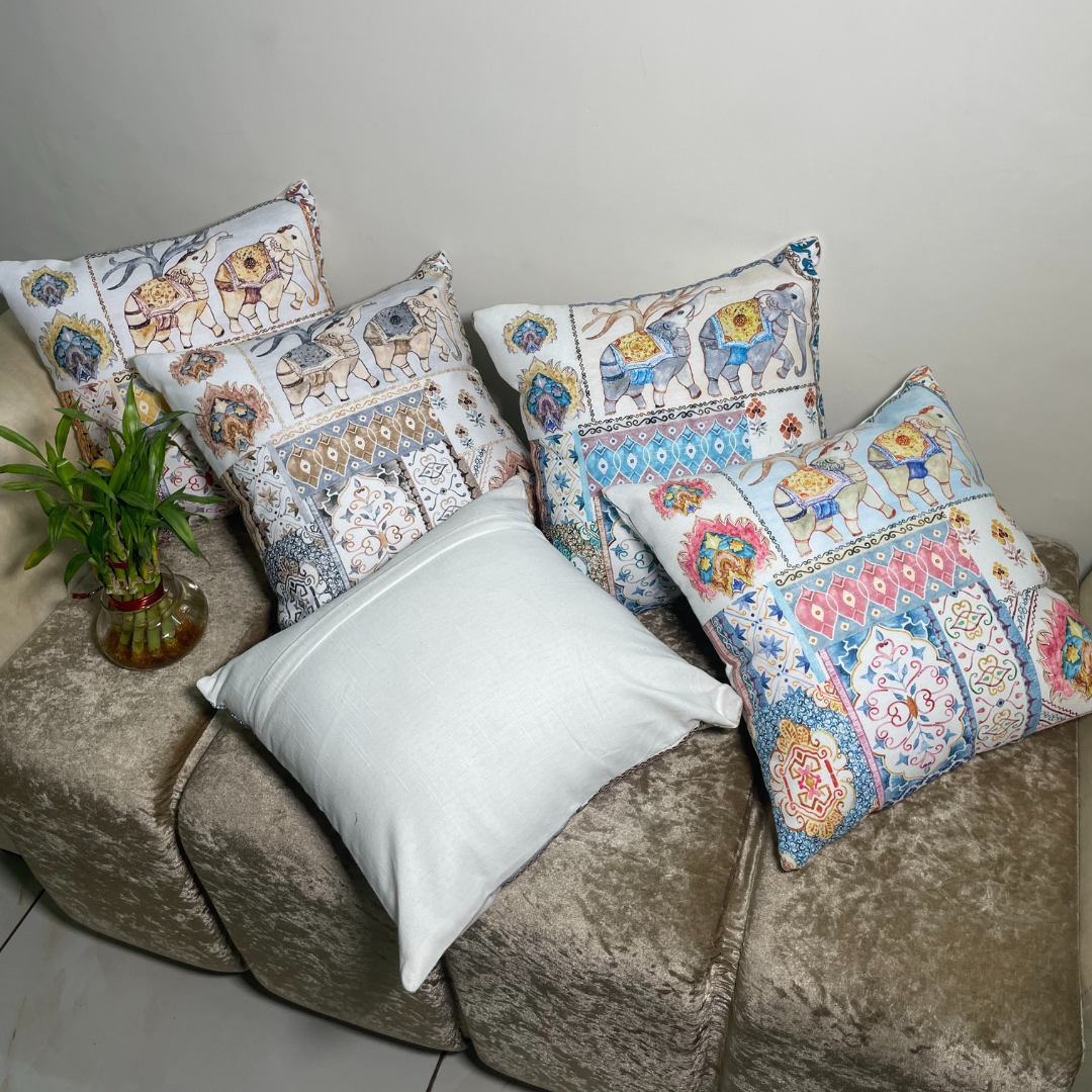 elephant printed cushion covers of 100% cotton material placed on sofa one cushion cover lies opposite showing zip on backside 