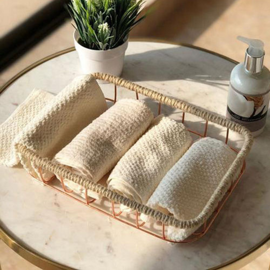 jute and iron wired basket placed on a marble table with four hand towels near planter and bottle 