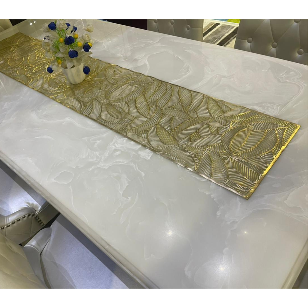 metallic look gold color table runner with leaf design on white marble dining table 