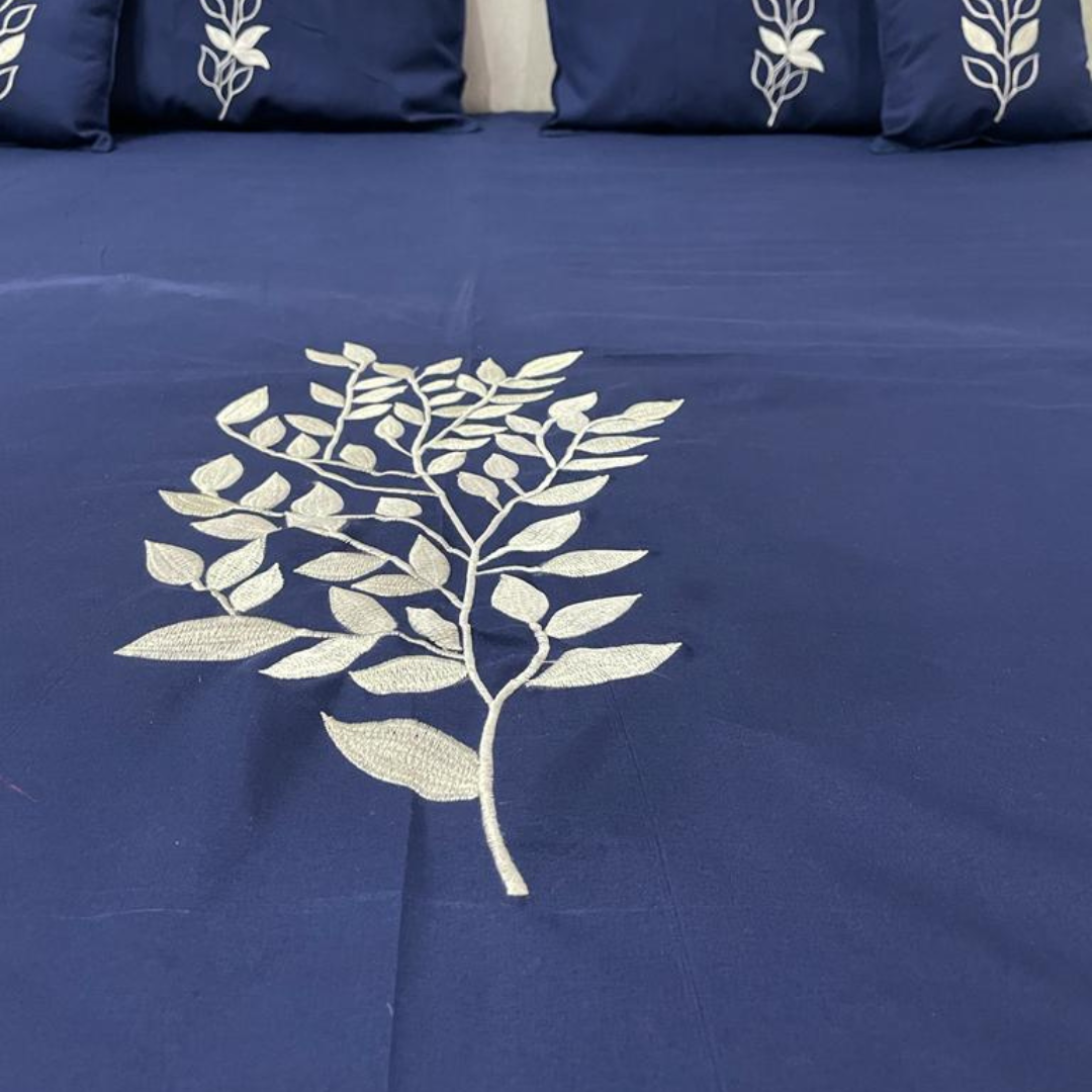 zoom view of leaves embroidery design on blue color bedsheet