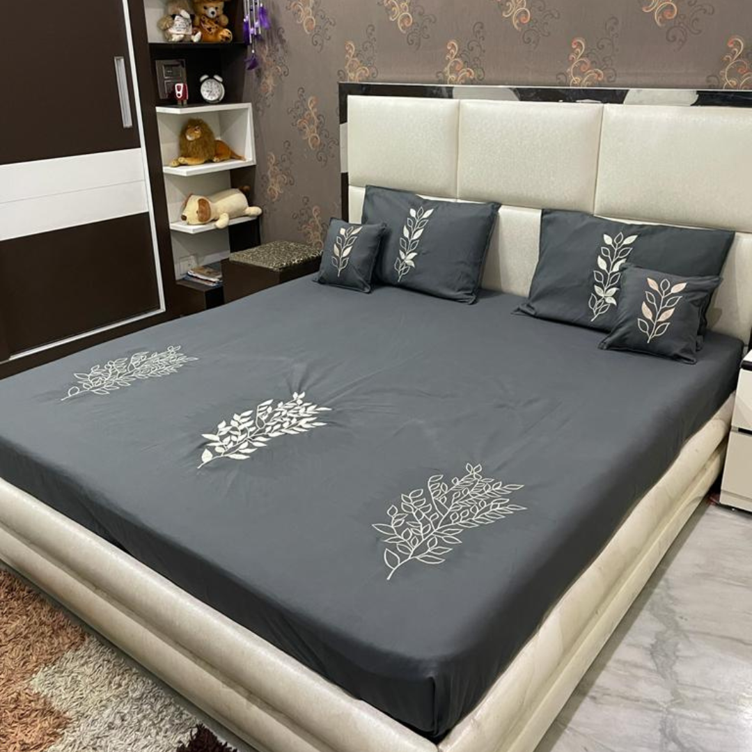 grey color glace cotton bedsheet with white embroidery design on bedsheet, filled cushions and pillow covers bedding set