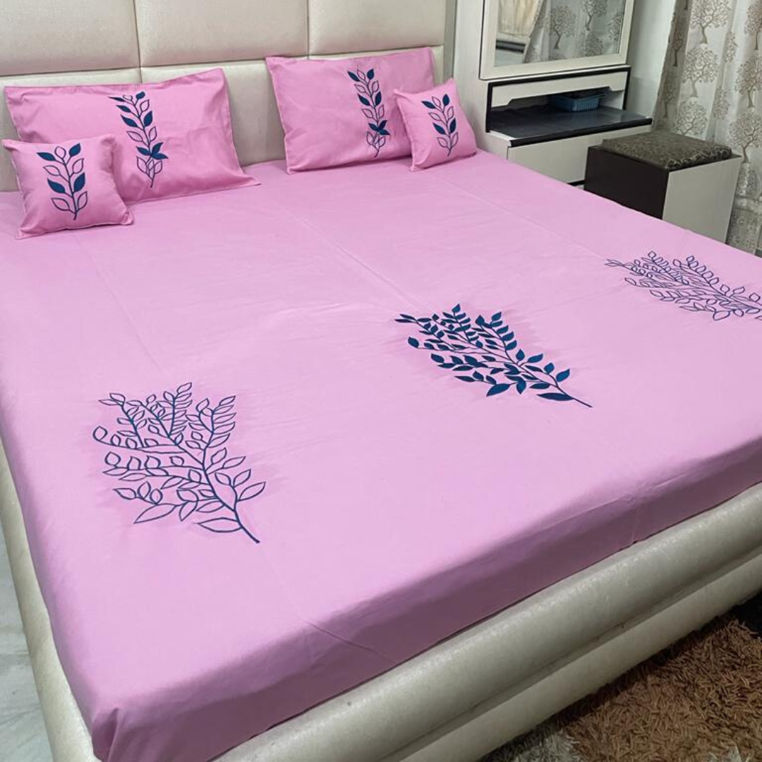 pink color glace cotton bedsheet with embroidery design on bedsheet, filled cushions and pillow covers bedding set