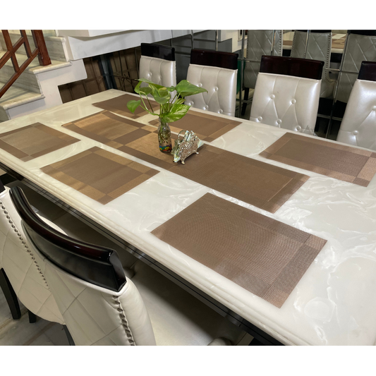 six placemats with one table runner in brown color on white six seater dining table accessoied with vase and napkin holder