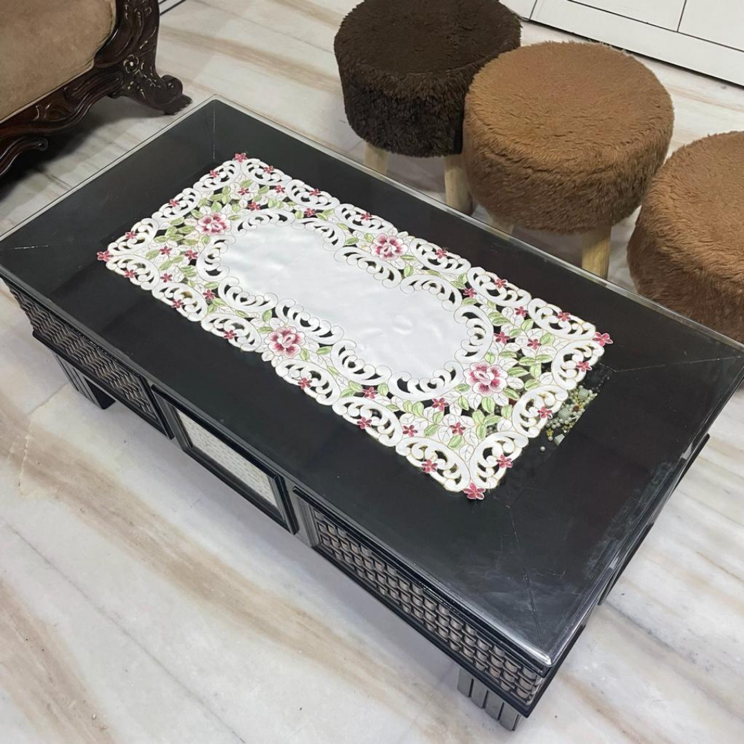 Tissue fabric embroidered with magenta flowers laser cut design placed on table 