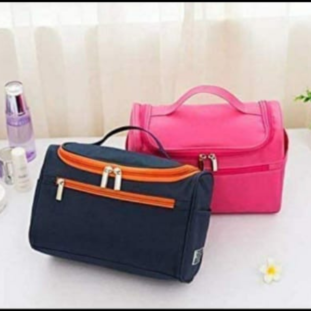 toiletry kit bag organizer in navy blue and pink color with dual zipper lying on table
