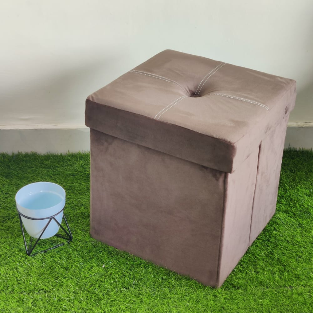 solid beige color velvet storage box with stool foam sitting small pot placed near stool on faux grass floor