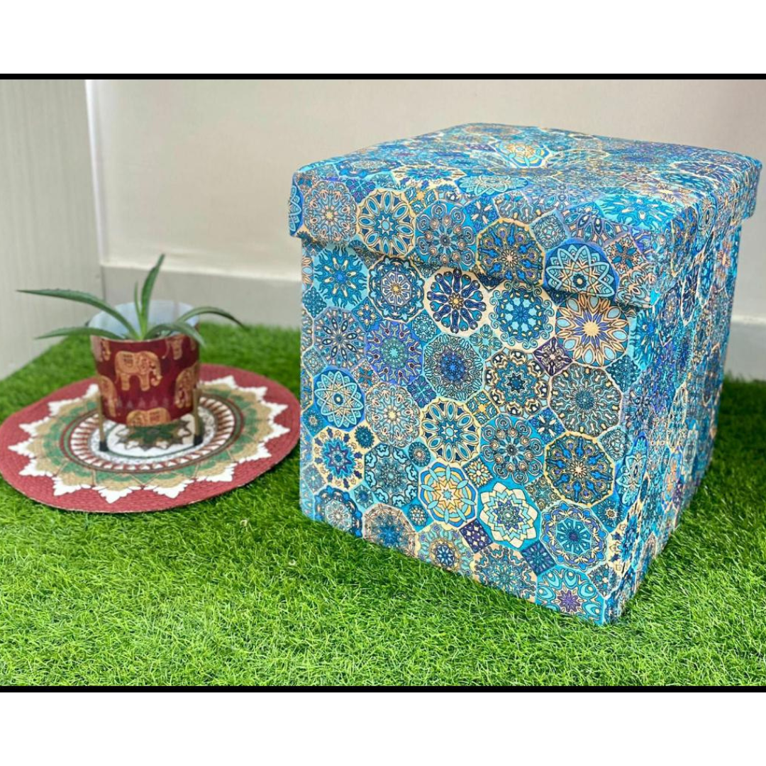 abstract printed blue color stool with storage placed on grass floor near small elephant printed pot