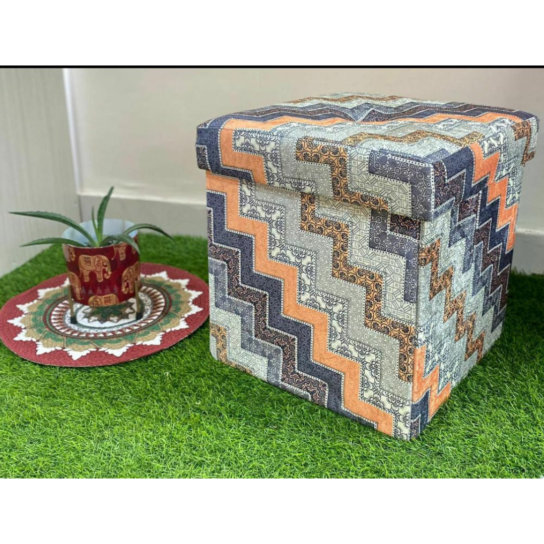abstract printed grey color stool with storage placed on grass floor near small elephant printed pot