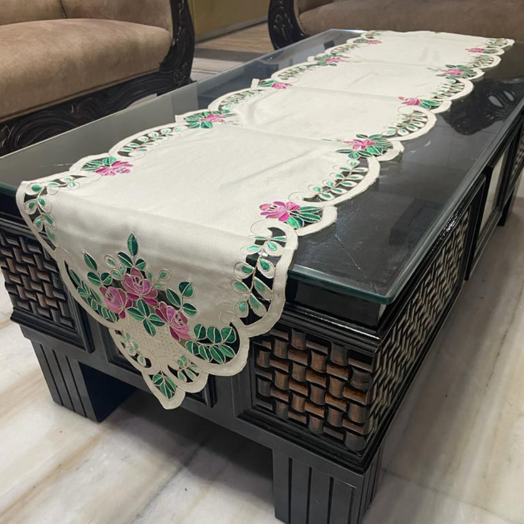 tissue fabric table runner embroidered with pink flowers and green leaves on border shaped cut design placed on the dining table side view