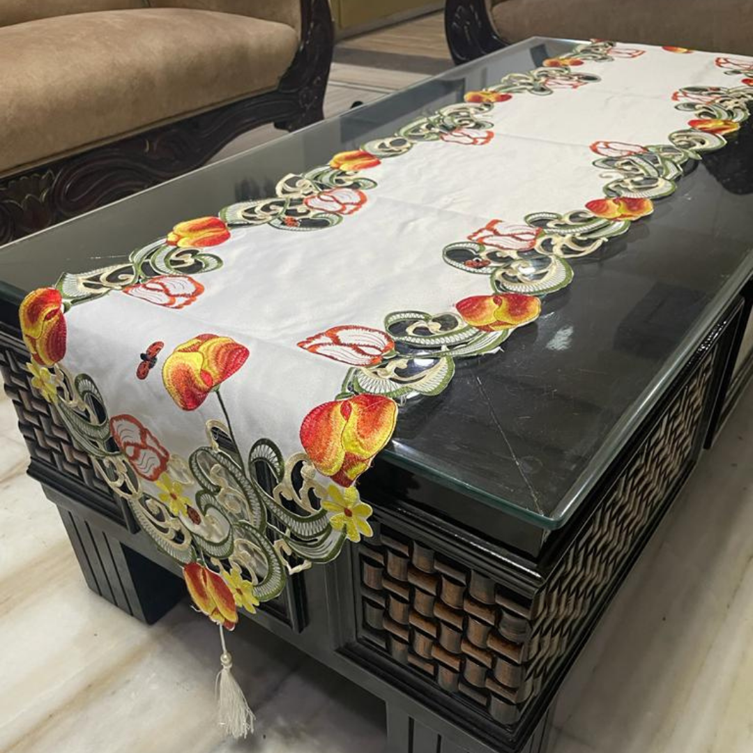 tissue fabric table runner embroidered with red flowers and green leaves on border shaped cut design placed on the dining table side view