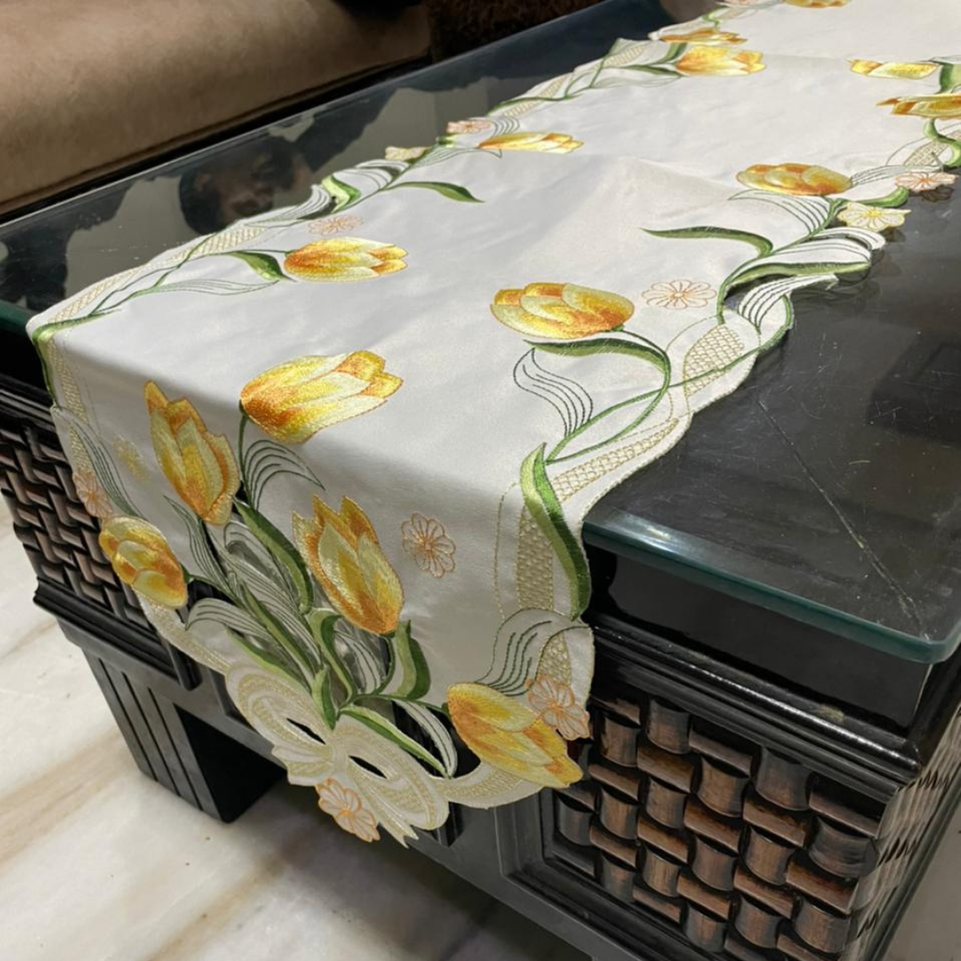 tissue fabric table runner embroidered with yellow flowers and green leaves on border shaped cut design placed on the dining table side view